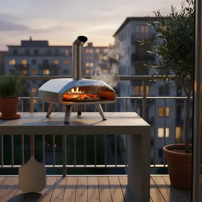 A compact gas pizza oven on a small, urban apartment balcony with a pizza inside.